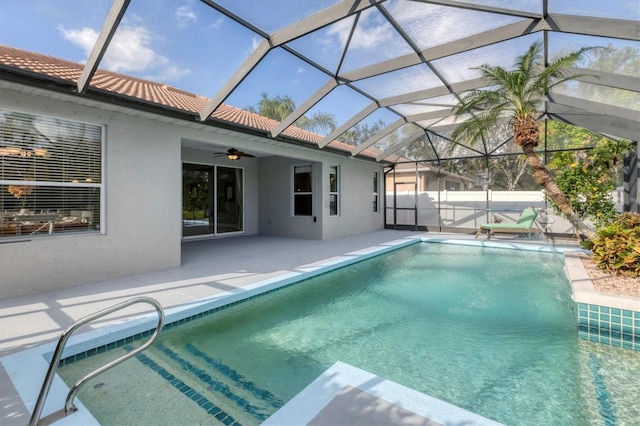 view of swimming pool with ceiling fan, a patio area, and glass enclosure