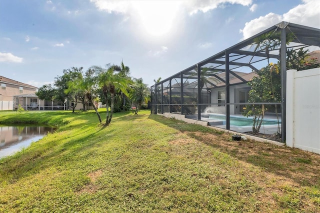 view of yard with a water view and glass enclosure