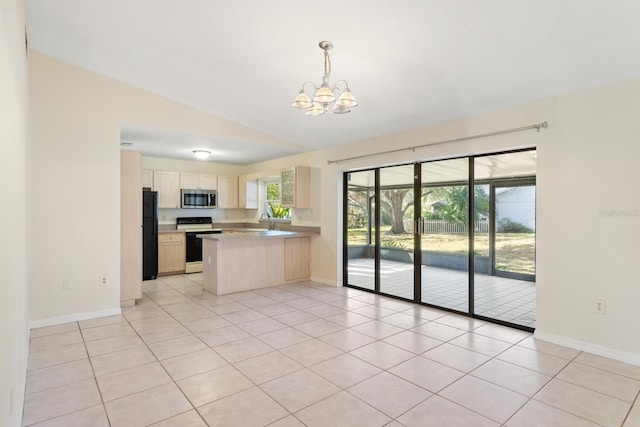 kitchen featuring kitchen peninsula, electric range, black fridge, and a healthy amount of sunlight