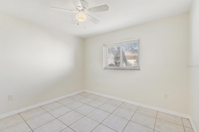 spare room with ceiling fan and light tile patterned floors