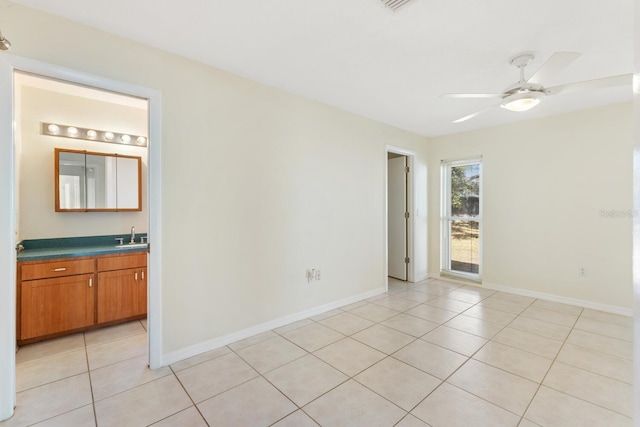 tiled spare room with ceiling fan and sink