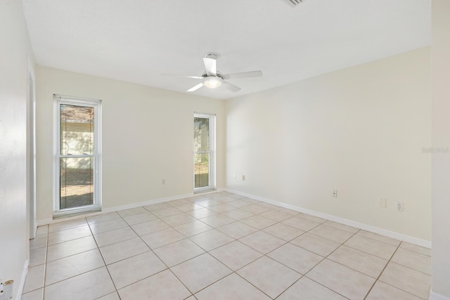 tiled empty room featuring ceiling fan and a healthy amount of sunlight