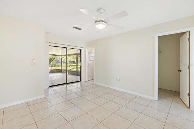 empty room with ceiling fan and light tile patterned floors