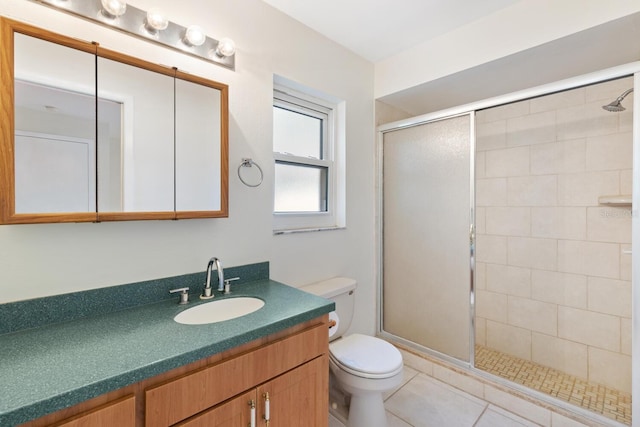 bathroom with tile patterned flooring, vanity, toilet, and walk in shower