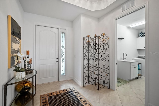 entryway featuring sink and light tile patterned flooring