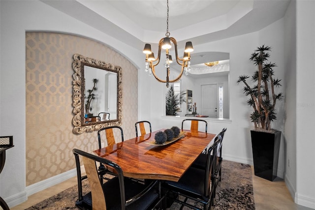 dining room featuring a raised ceiling and a chandelier