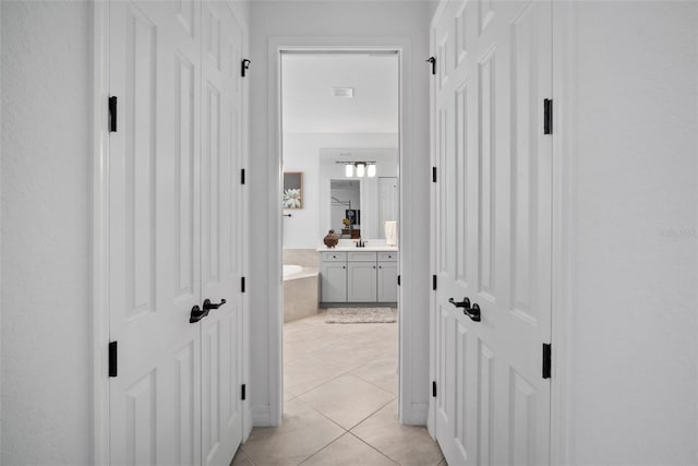 hallway featuring light tile patterned floors and sink