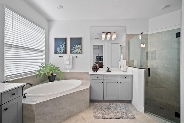 bathroom with shower with separate bathtub, vanity, and tile patterned floors