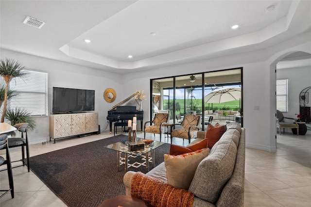 tiled living room featuring a tray ceiling