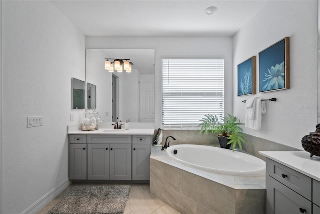 bathroom featuring tiled bath, tile patterned flooring, and vanity