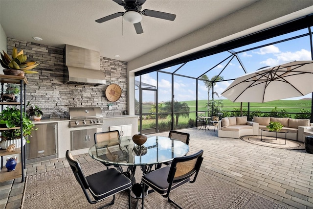 view of patio featuring outdoor lounge area, glass enclosure, grilling area, ceiling fan, and area for grilling