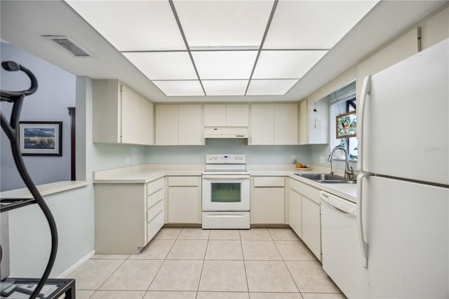 kitchen featuring sink, light tile patterned flooring, and white appliances