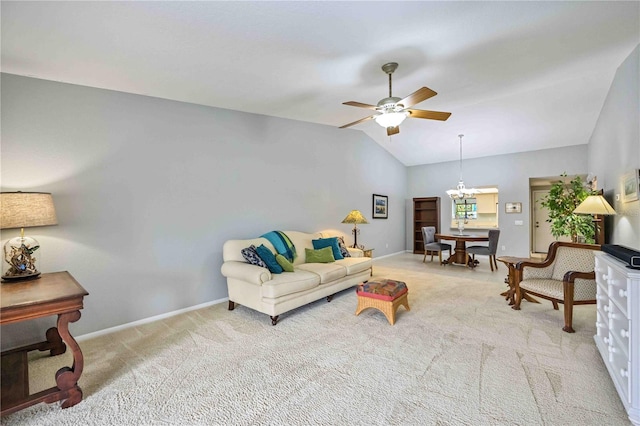 carpeted living room featuring ceiling fan with notable chandelier and vaulted ceiling