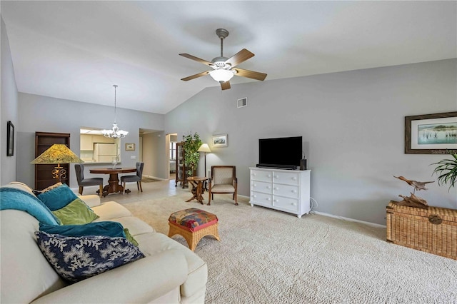 living room featuring ceiling fan with notable chandelier, light carpet, and vaulted ceiling