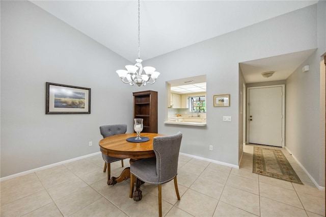 dining space with a chandelier, light tile patterned floors, vaulted ceiling, and sink