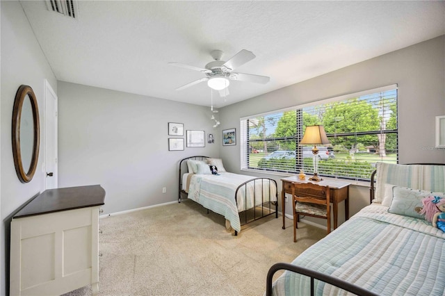 bedroom featuring multiple windows, ceiling fan, and light colored carpet