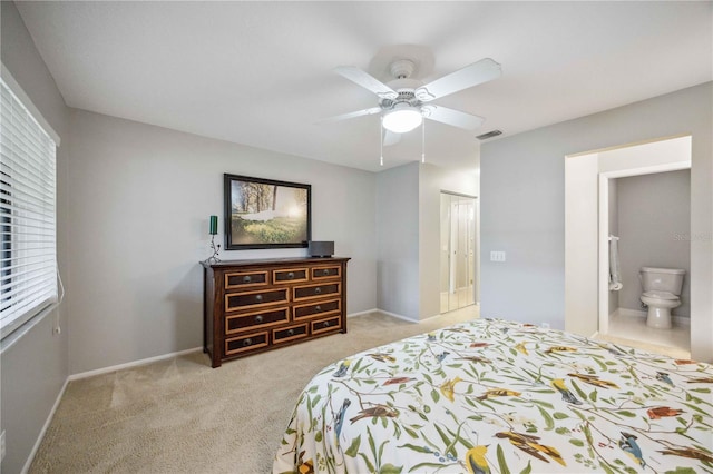 carpeted bedroom with ensuite bath and ceiling fan