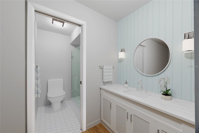 bathroom with tile patterned floors, vanity, wood walls, and toilet