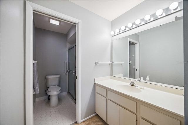 bathroom with toilet, vanity, tile patterned floors, and a shower with shower door