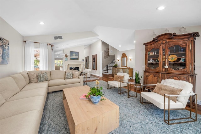 living room featuring wood-type flooring and vaulted ceiling