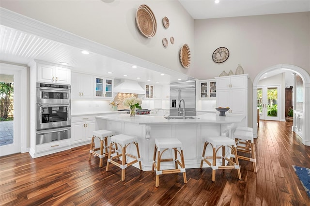 kitchen with a wealth of natural light, white cabinetry, a spacious island, and appliances with stainless steel finishes