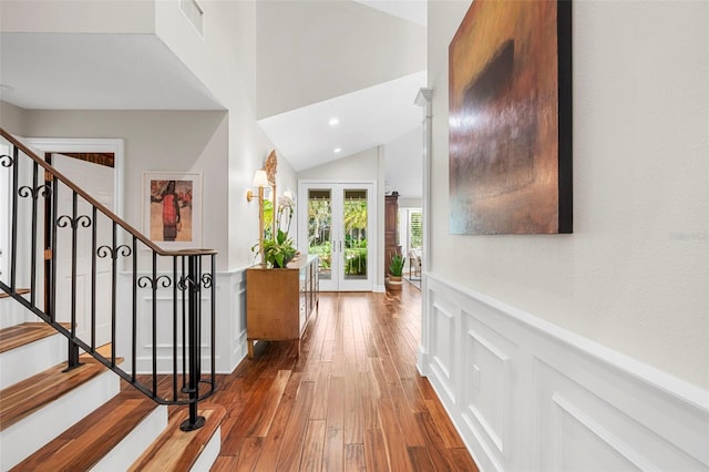 foyer with hardwood / wood-style floors, lofted ceiling, and french doors