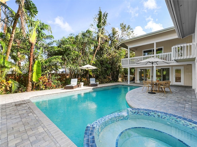 view of swimming pool featuring a patio area, an in ground hot tub, and french doors