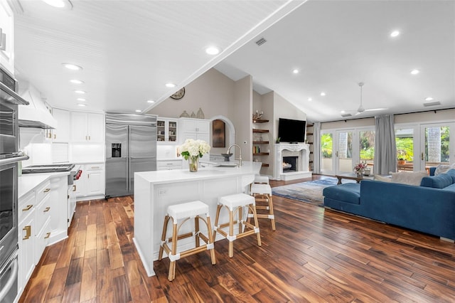 kitchen featuring a large island, dark hardwood / wood-style floors, white cabinetry, and built in refrigerator