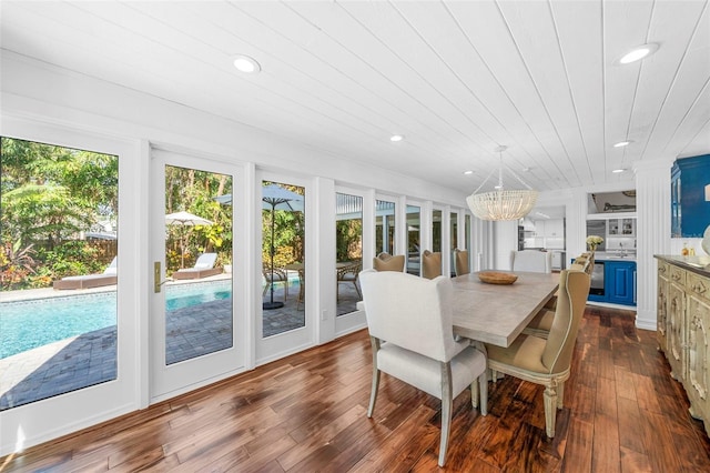 dining area with dark hardwood / wood-style flooring, wooden ceiling, and an inviting chandelier