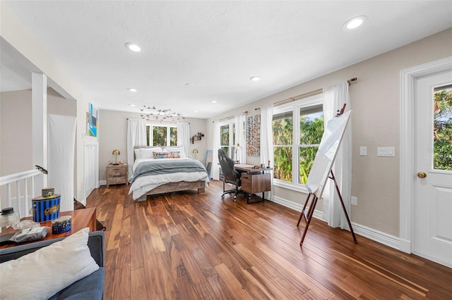 bedroom with multiple windows and dark wood-type flooring