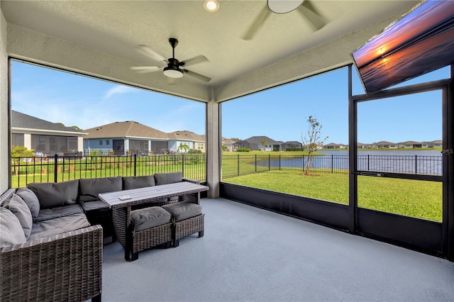 sunroom / solarium with a water view and ceiling fan