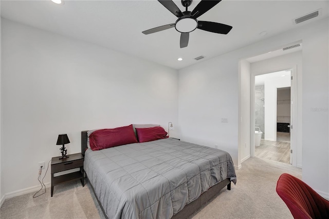 bedroom featuring light colored carpet, ceiling fan, and ensuite bathroom