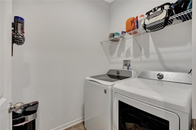 clothes washing area with wood-type flooring and separate washer and dryer