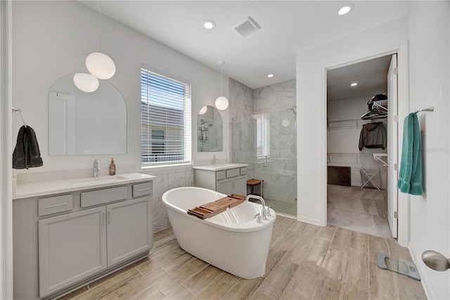 bathroom featuring shower with separate bathtub, wood-type flooring, and tile walls