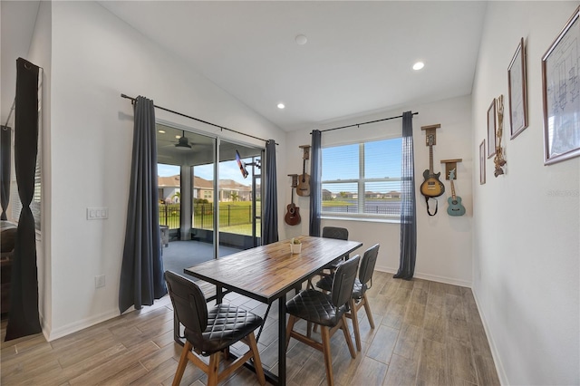 dining space featuring lofted ceiling and light hardwood / wood-style flooring