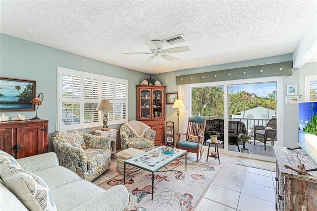 living room with light tile patterned floors, a textured ceiling, and ceiling fan