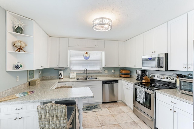 kitchen featuring white cabinets, light tile patterned floors, sink, and appliances with stainless steel finishes