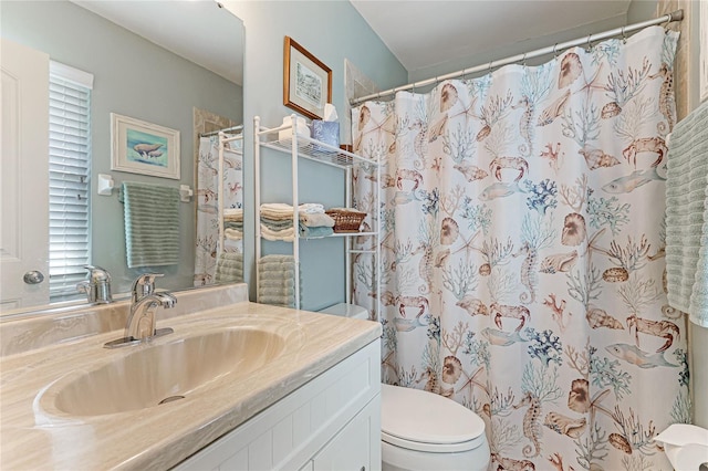 bathroom with a shower with shower curtain, vanity, and toilet