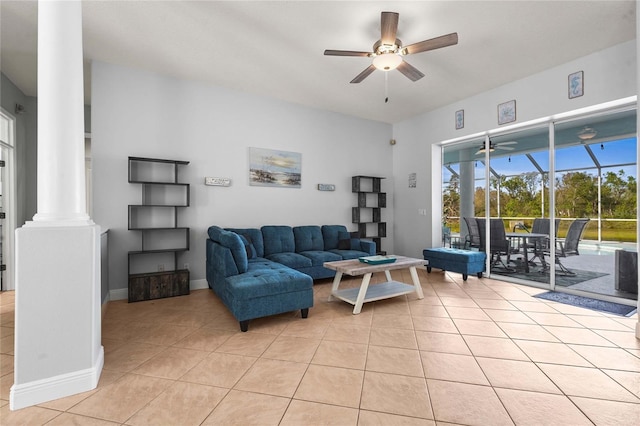 living area featuring light tile patterned flooring, baseboards, ornate columns, and ceiling fan