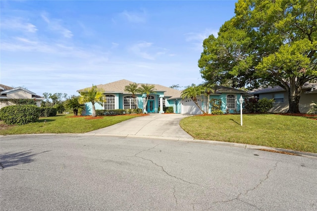 single story home with an attached garage, concrete driveway, and a front lawn