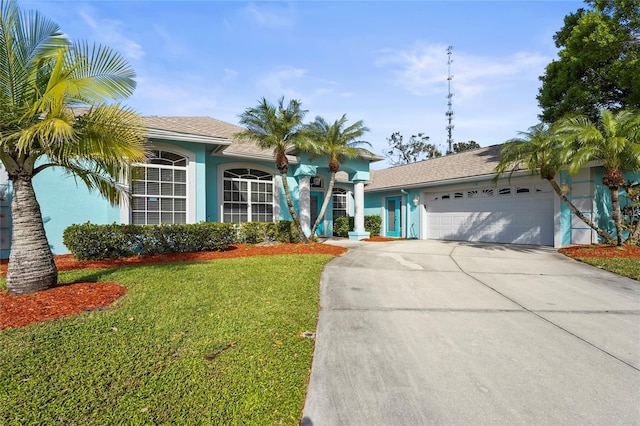 ranch-style house featuring stucco siding, driveway, an attached garage, and a front lawn