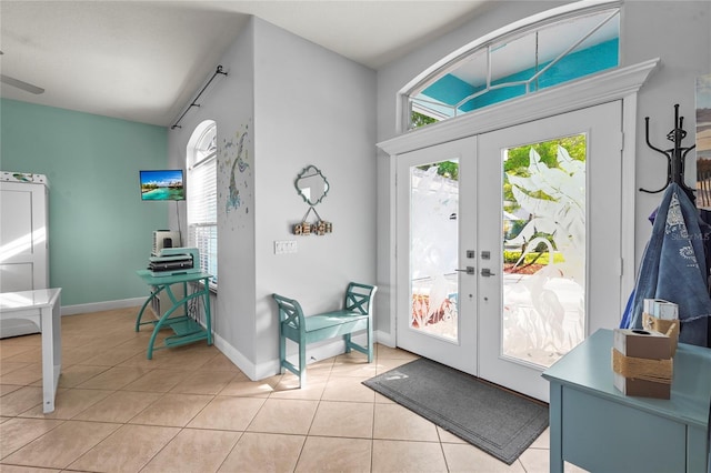 entryway with light tile patterned floors, french doors, baseboards, and a wealth of natural light