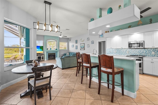 kitchen featuring light tile patterned floors, plenty of natural light, a fireplace, and stainless steel appliances