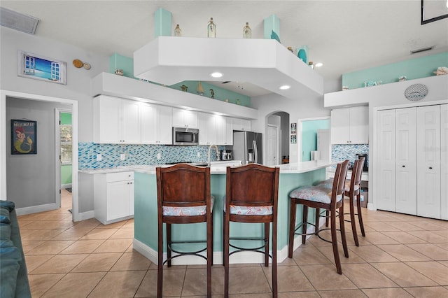 kitchen featuring light tile patterned floors, white cabinetry, stainless steel appliances, and light countertops