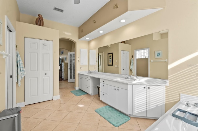 full bathroom with visible vents, two vanities, a sink, a closet, and tile patterned flooring