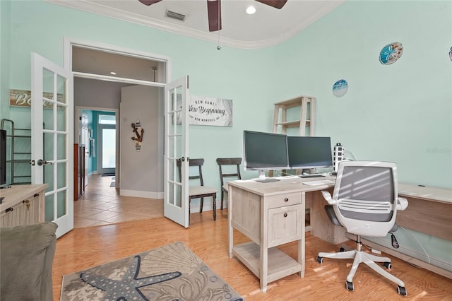 office with a ceiling fan, visible vents, light wood-style flooring, french doors, and crown molding