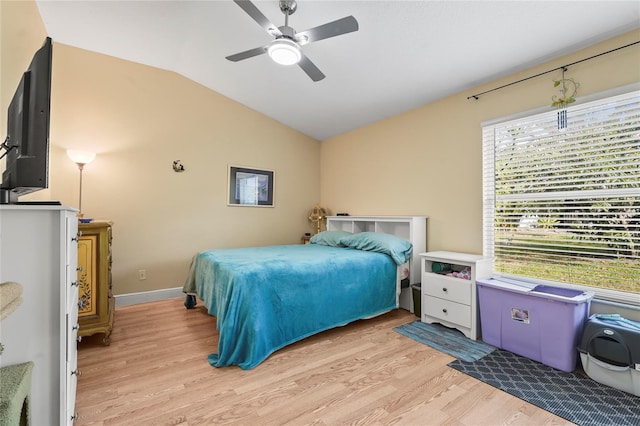 bedroom with baseboards, a ceiling fan, light wood-style floors, and vaulted ceiling