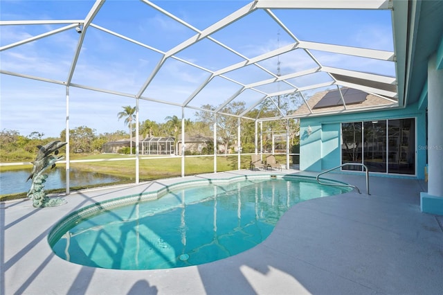 pool with a patio area, glass enclosure, and a water view