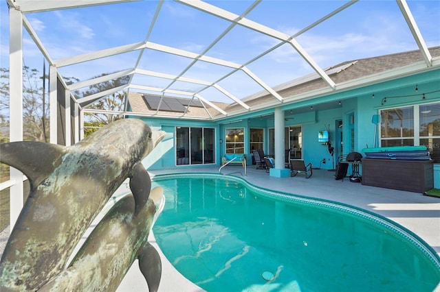 outdoor pool featuring glass enclosure, a hot tub, a patio, and a ceiling fan