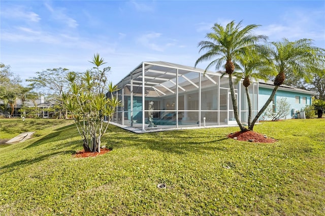 back of property with a lanai, a yard, and an outdoor pool